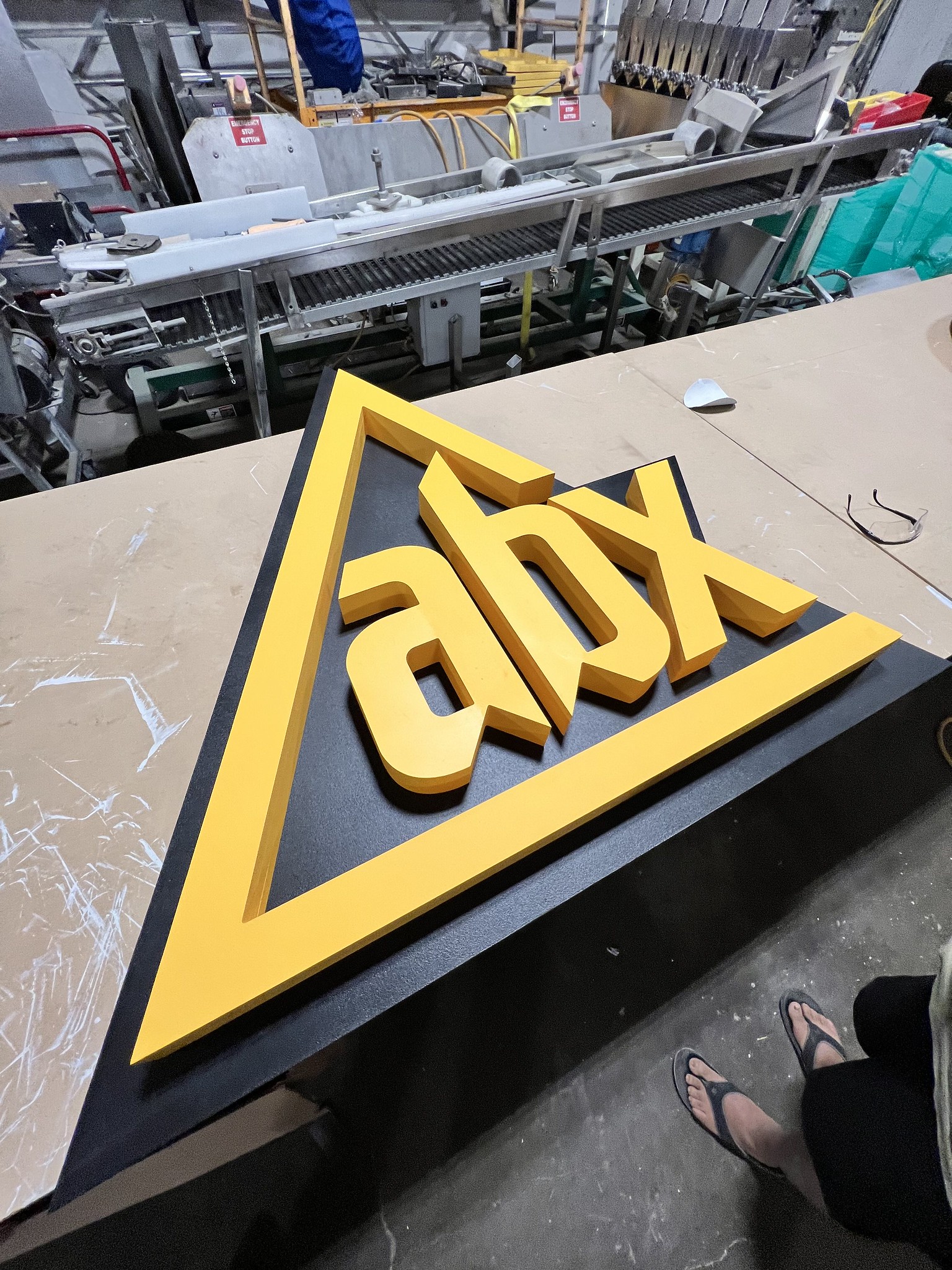 Yellow CNC-cut dimensional sign in the fabrication shop